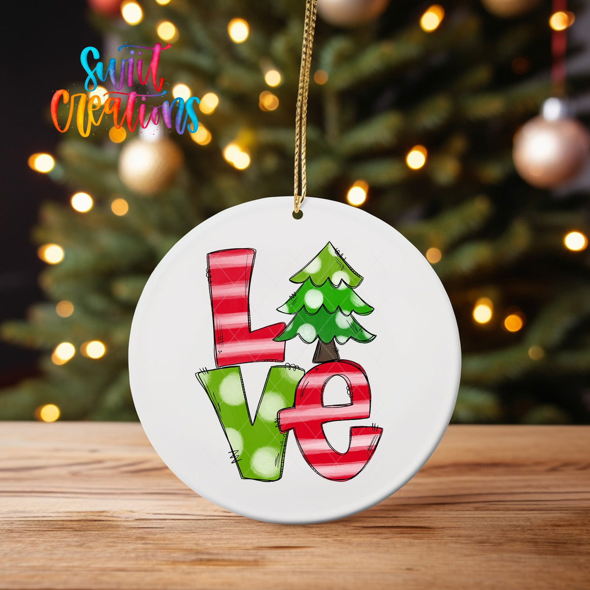 Christmas Love ornament UV DTF transfer on an ornament on a wooden table with tree lights behind it