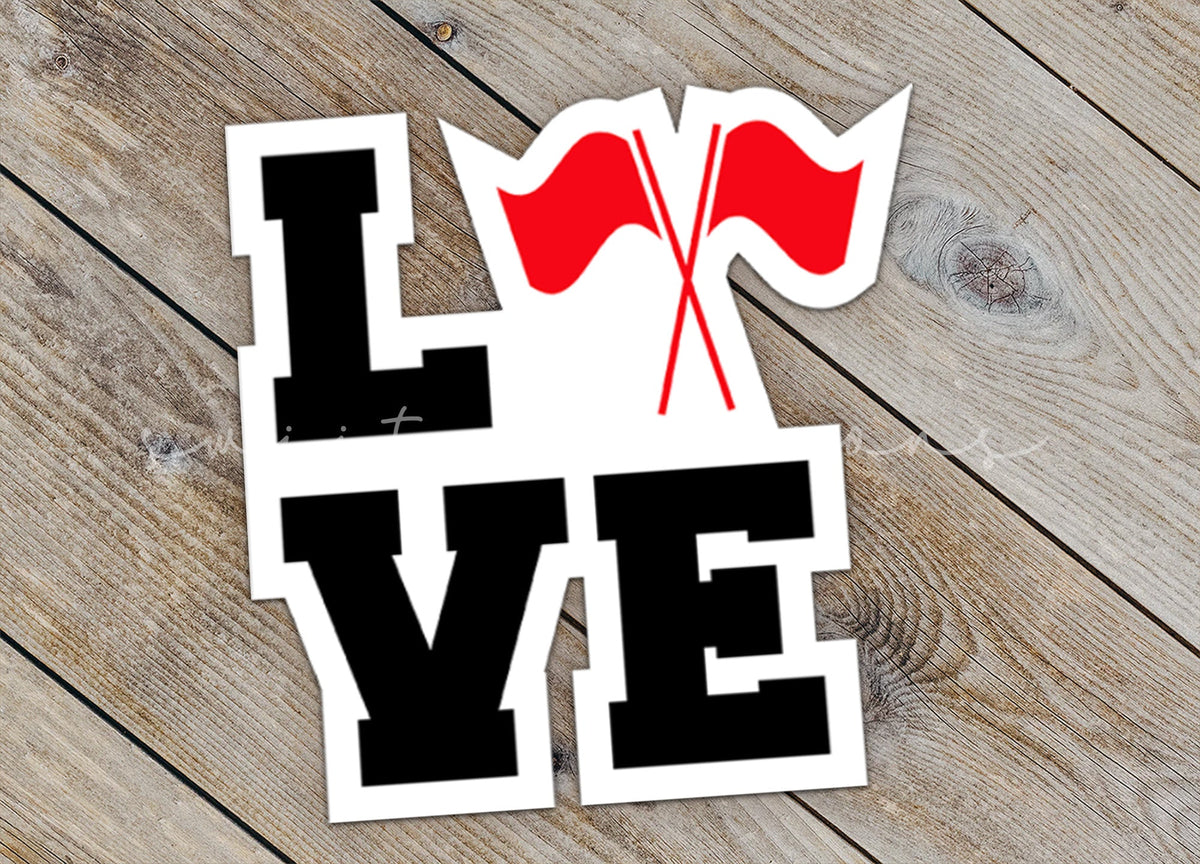 Close-up of the Red Love Color Guard sticker on rustic wood