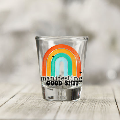 Close-up of the Manifesting Good Sh*t UV DTF transfer on a clear shot glass
