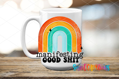 Manifesting Good Sh*t UV DTF transfer on a white ceramic coffee mug