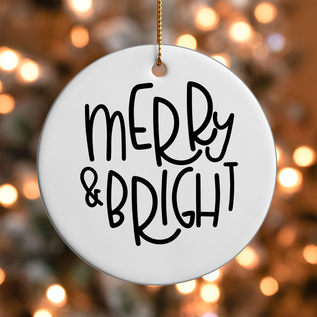 Merry and Bright ornament UV DTF transfer on a round white ornament with a bokeh light background