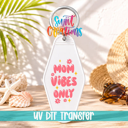 Mom Vibes Only motel keychain UV DTF transfer on a white keychain in a beach scene
