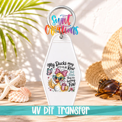 My Ducks May Not Be in a Row motel keychain UV DTF transfer on a white keychain in a beach scene