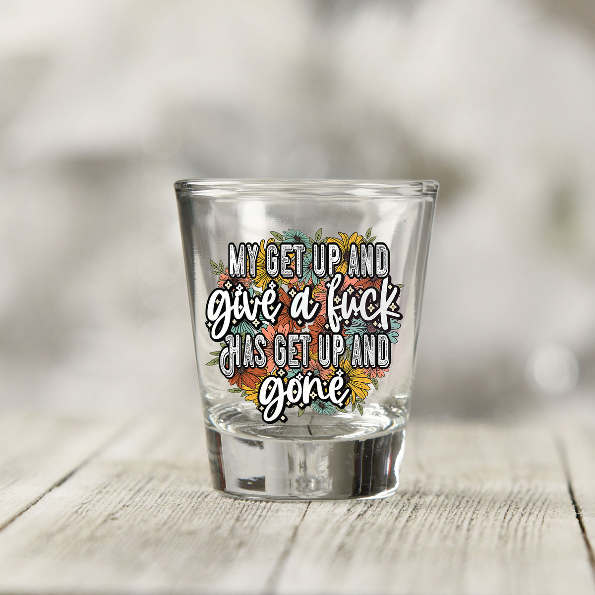Close-up of the My Get Up and Give a F*ck UV DTF transfer on a clear shot glass