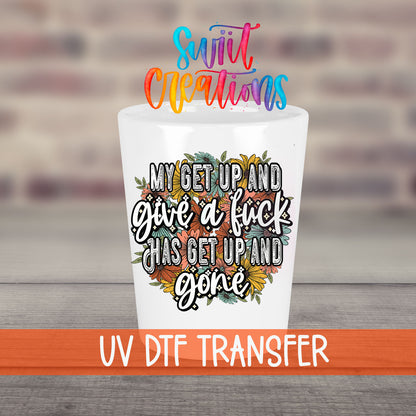 My Get Up and Give a F*ck UV DTF transfer on a white shot glass in front of a brick wall