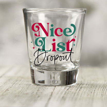 Nice List Dropout Christmas shot glass UV DTF transfer with red and green serif lettering with black script on a clear shot glass