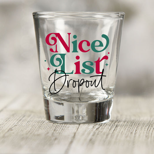 Nice List Dropout Christmas shot glass UV DTF transfer with red and green serif lettering with black script on a clear shot glass