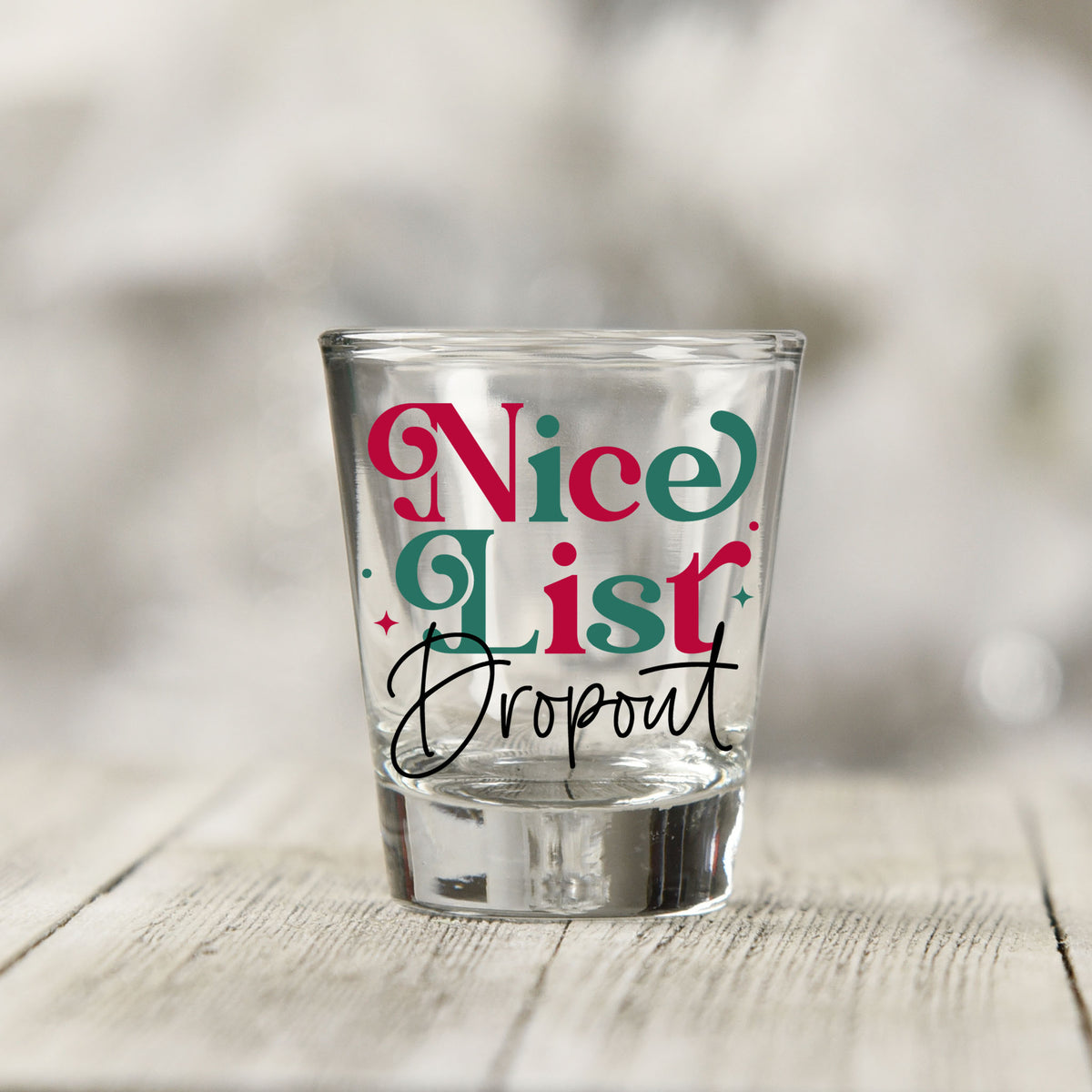 Close-up of the Nice List Dropout Christmas UV DTF transfer on a clear shot glass