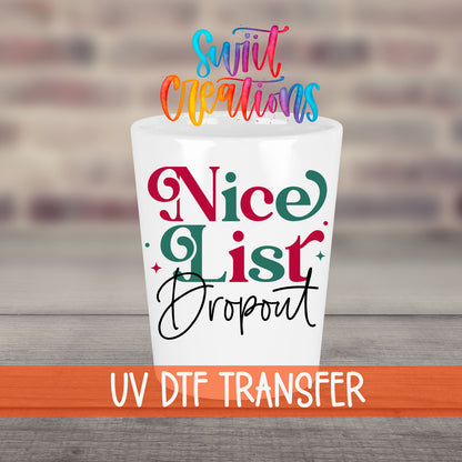 Nice List Dropout Christmas UV DTF transfer on a white shot glass in front of a brick wall