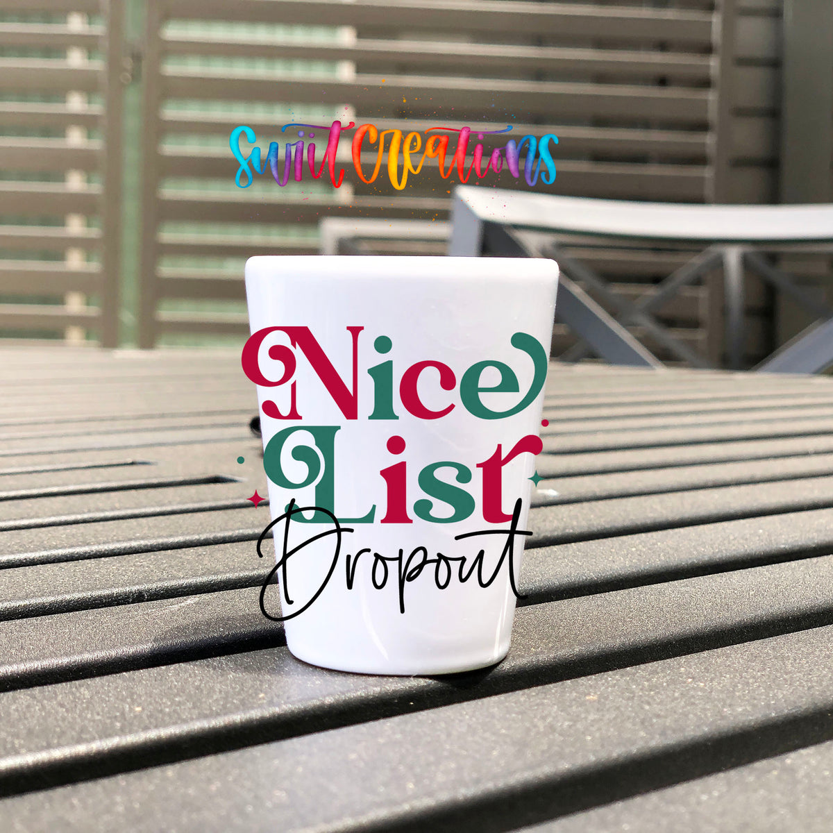 Nice List Dropout Christmas UV DTF transfer on a white shot glass on an outdoor patio table