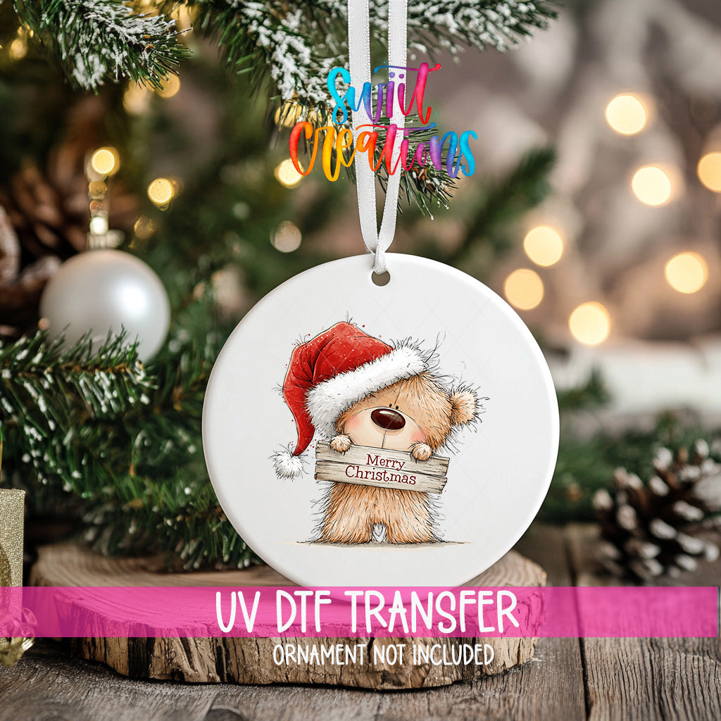Christmas teddy bear ornament UV DTF transfer in Santa hat holding Merry Christmas sign, mockup view 2