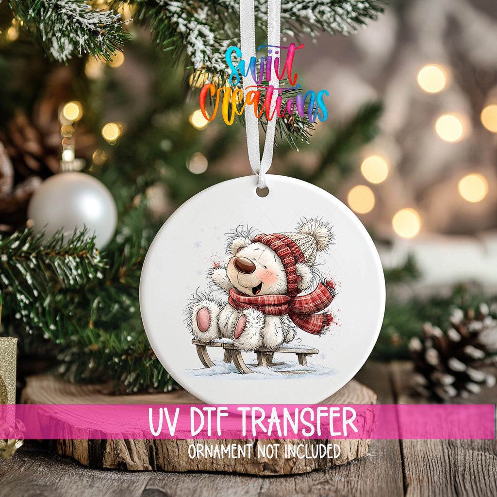 White Christmas bear ornament UV DTF transfer beside decorated tree and wrapped gifts, mockup view 2