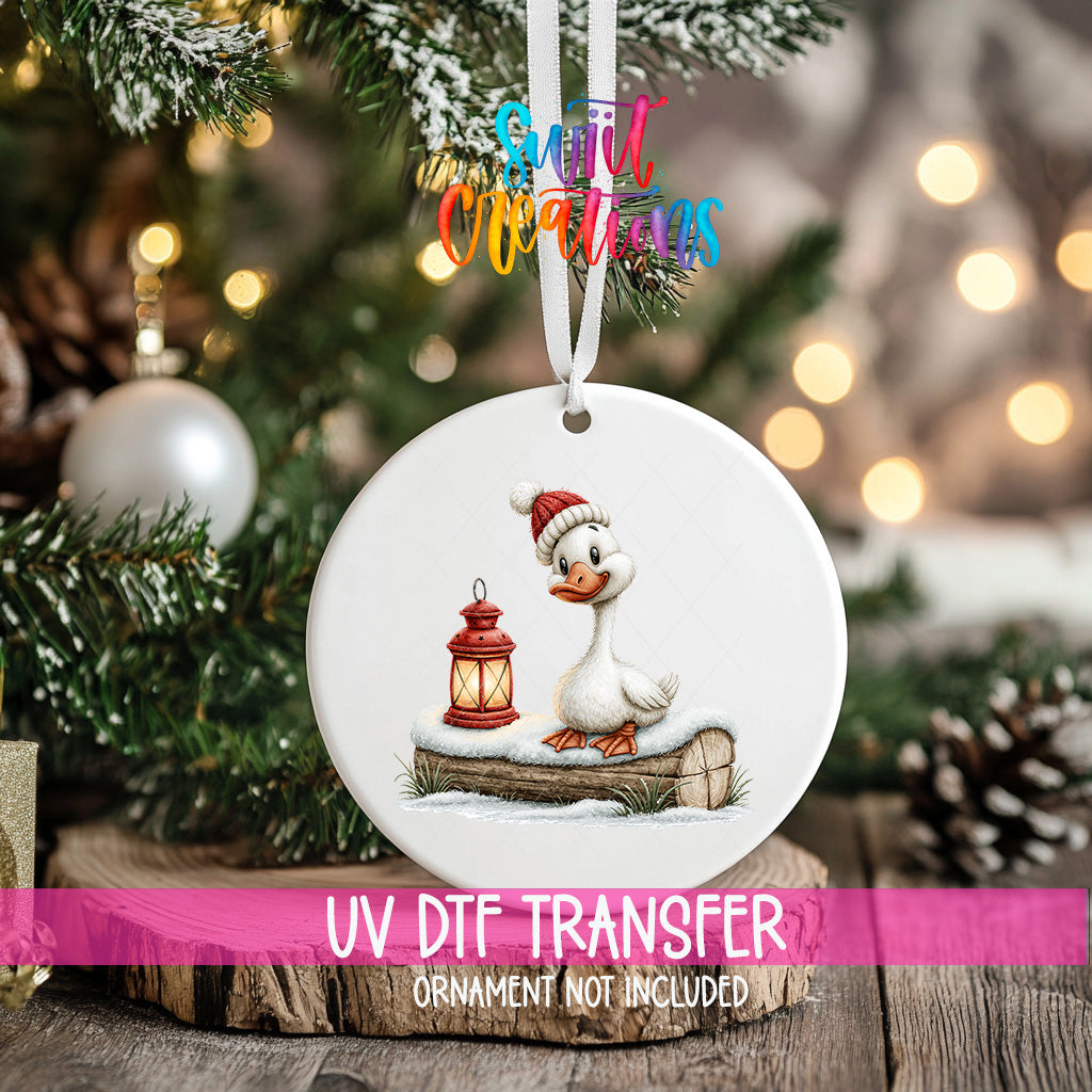 Christmas goose ornament UV DTF transfer in knit hat beside glowing red lantern, mockup view 2