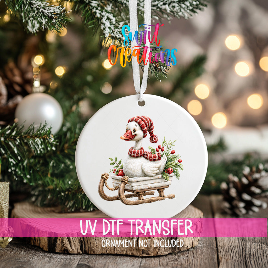 Christmas goose ornament UV DTF transfer riding wooden sleigh with greenery and red berries, mockup view 2