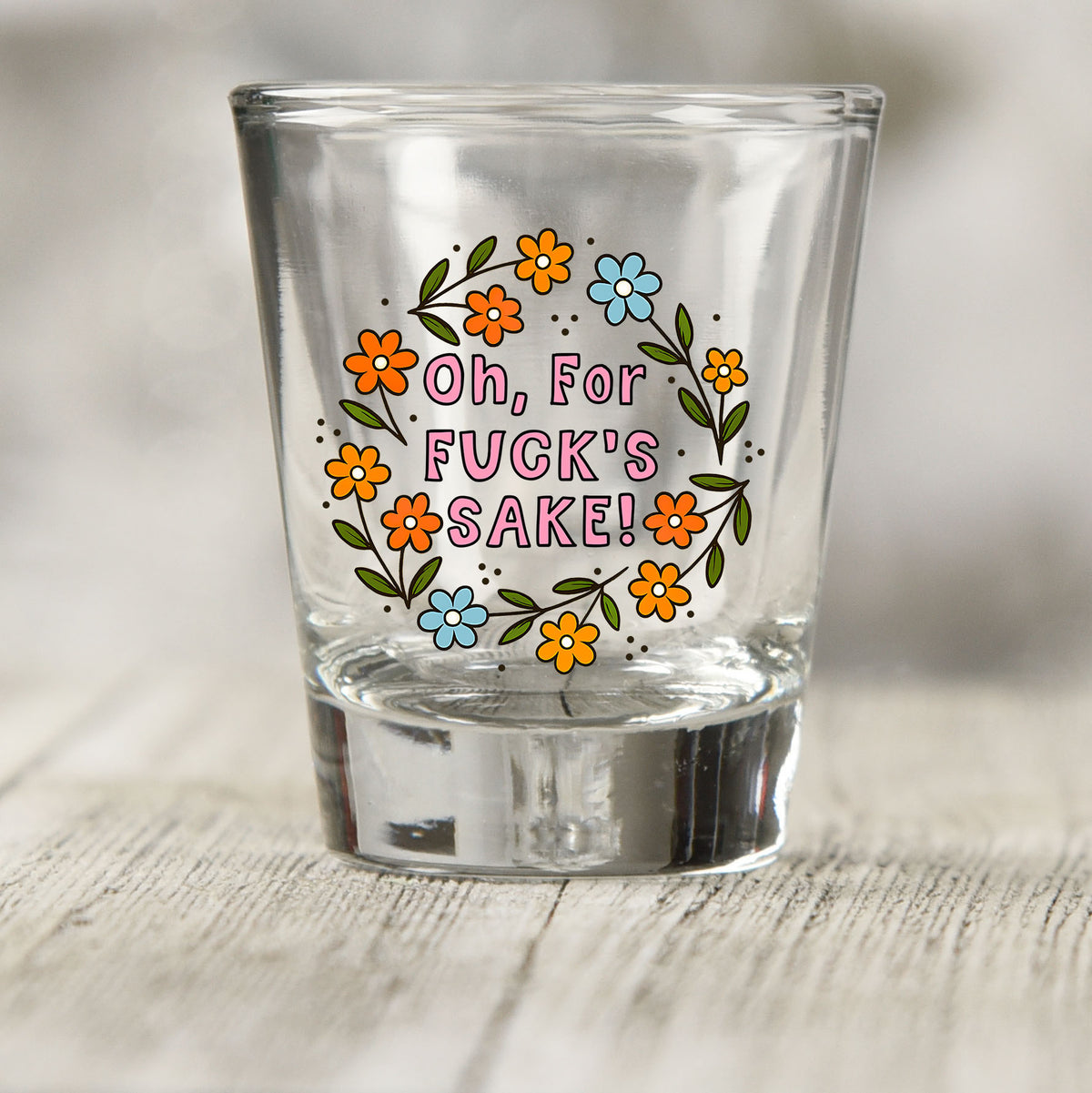 Oh For Fuck's Sake Floral shot glass UV DTF transfer with orange and blue floral wreath on a clear shot glass
