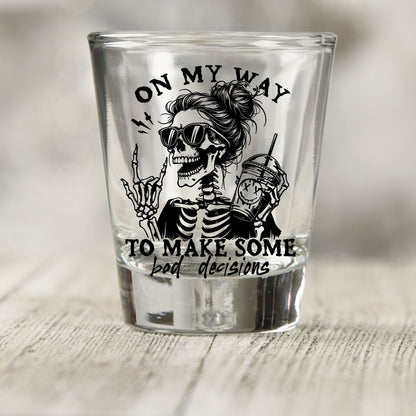 On My Way to Make Bad Decisions shot glass UV DTF transfer with skeleton with a messy bun and sunglasses on a clear shot glass