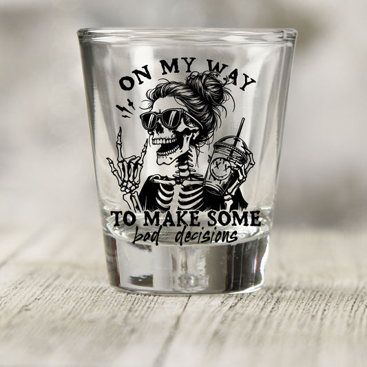 On My Way to Make Bad Decisions shot glass UV DTF transfer with skeleton with a messy bun and sunglasses on a clear shot glass