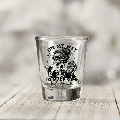 Close-up of the On My Way to Make Bad Decisions UV DTF transfer on a clear shot glass
