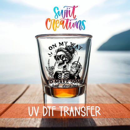 On My Way to Make Bad Decisions shot glass UV DTF transfer on a filled shot glass on a dock by the water