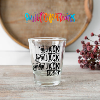 One Jack Two Jack Three Jack Floor shot glass transfer on a clear glass beside a wooden barrel and dried flowers
