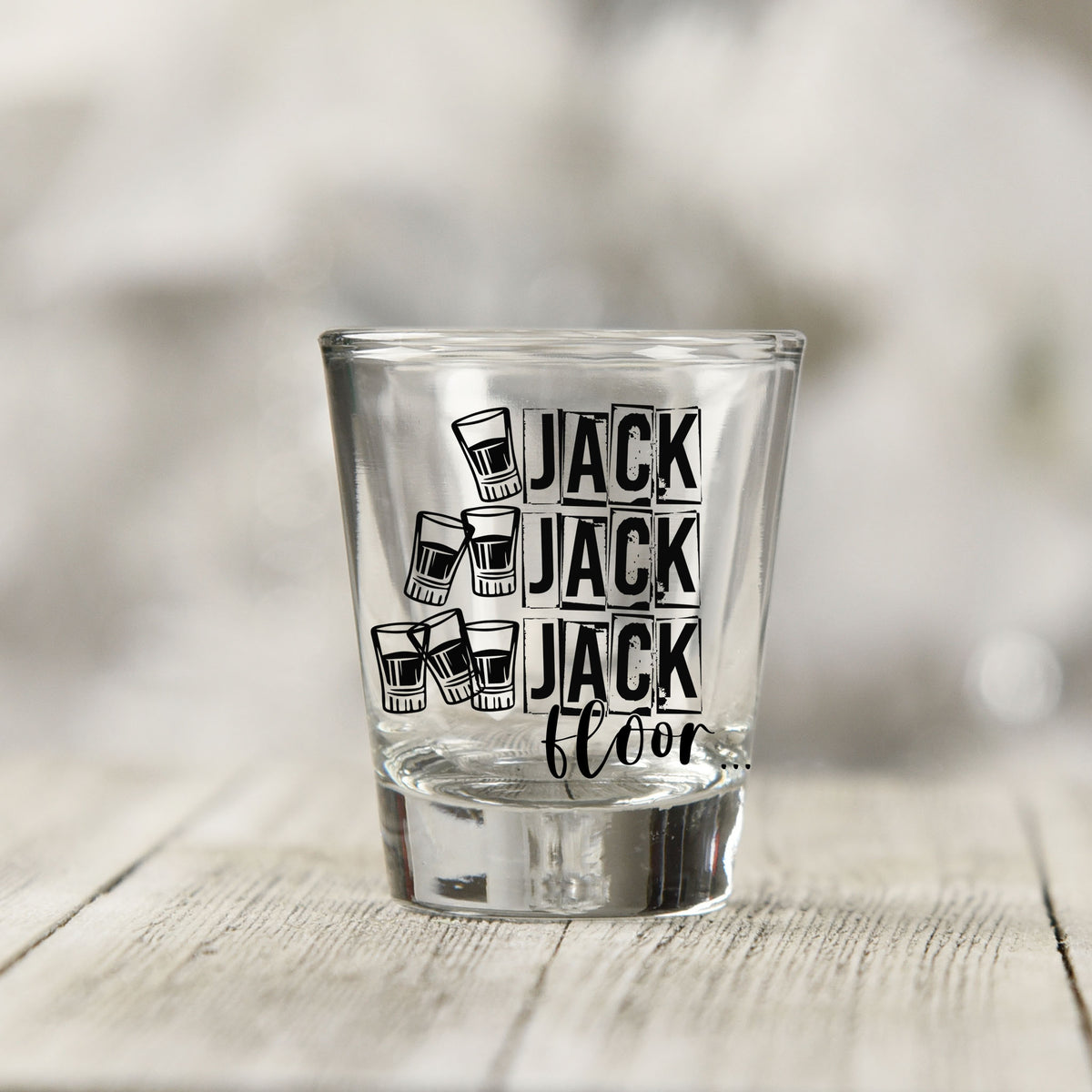 Close-up of the One Jack Two Jack Three Jack Floor UV DTF transfer on a clear shot glass