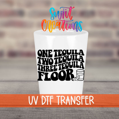 One Tequila Two Tequila UV DTF transfer on a white shot glass in front of a brick wall