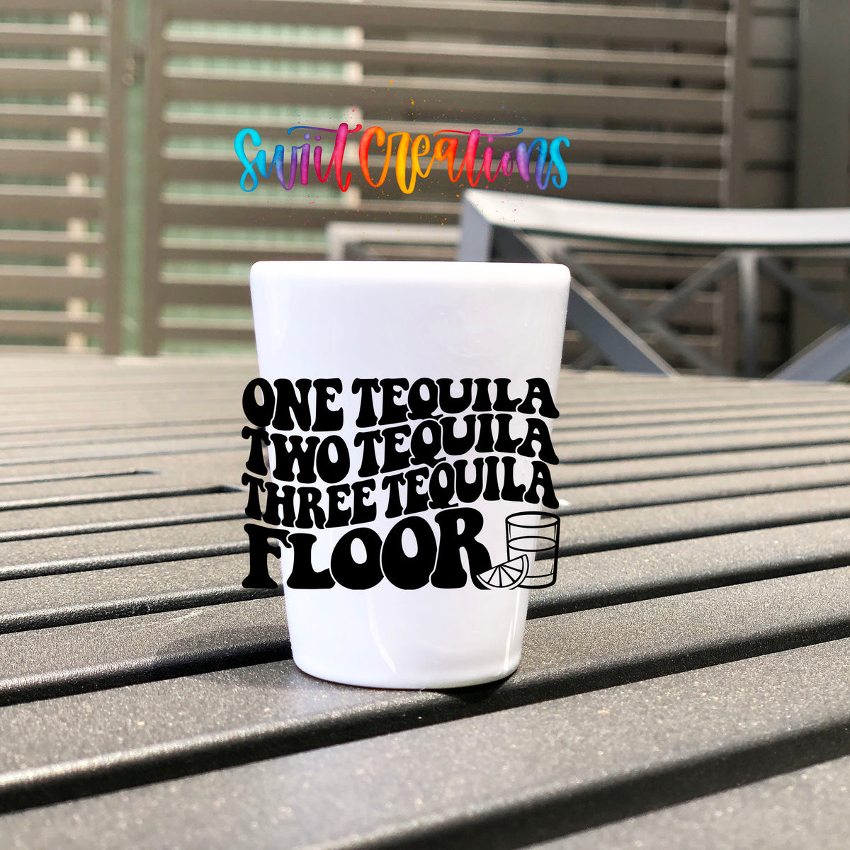 One Tequila Two Tequila UV DTF transfer on a white shot glass on an outdoor patio table