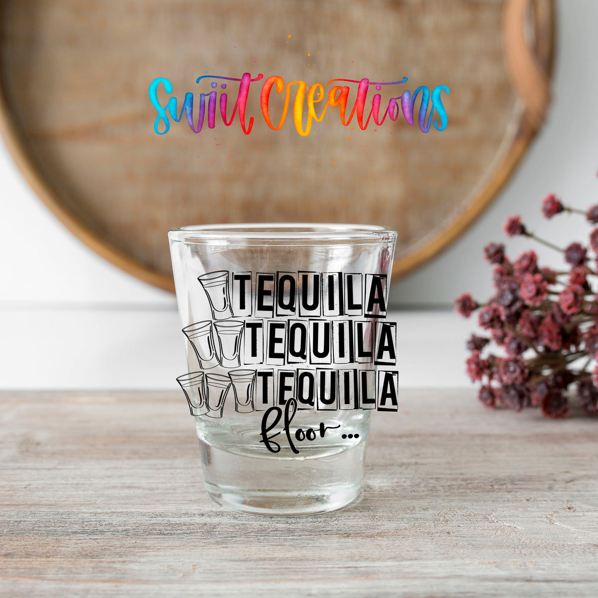 One Tequila Two Tequila Three Tequila Floor shot glass transfer on a clear glass beside a wooden barrel and dried flowers