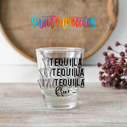 One Tequila Two Tequila Three Tequila Floor shot glass transfer on a clear glass beside a wooden barrel and dried flowers