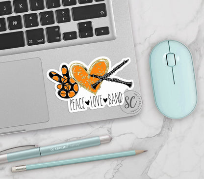Peace Love Band Clarinet vinyl sticker on a silver laptop next to a mint mouse and pens