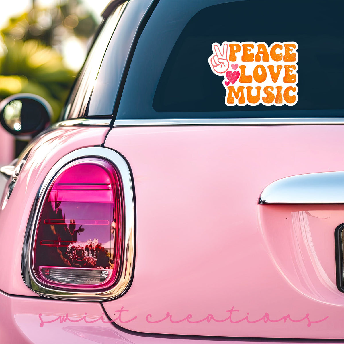 Peace Love Music sticker on the back window of a pink car
