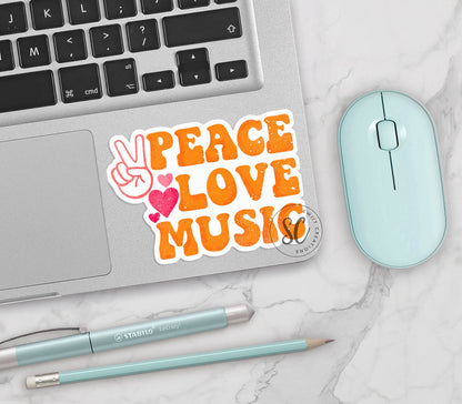 Peace Love Music vinyl sticker on a silver laptop next to a mint mouse and pens