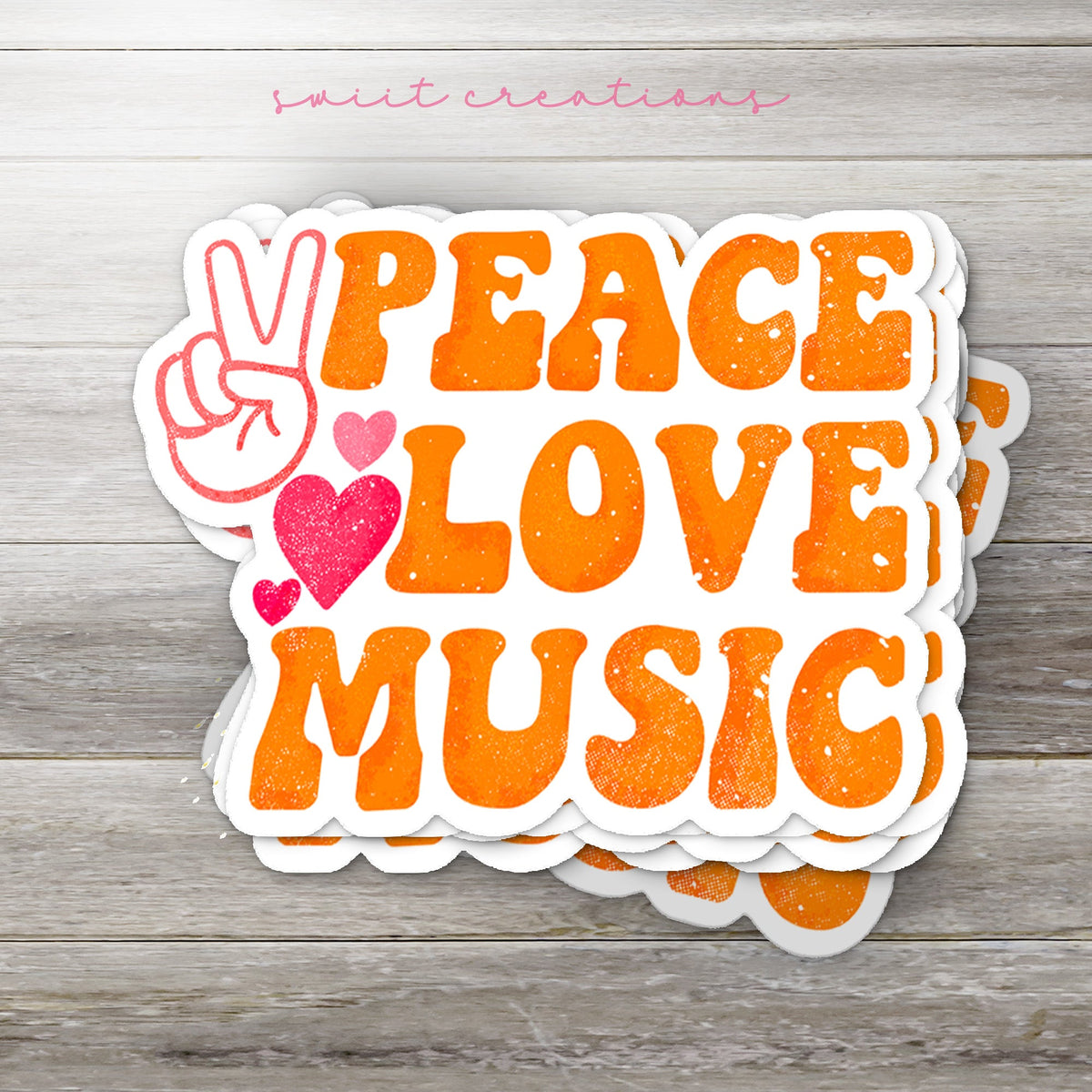 Stack of Peace Love Music glossy stickers on a gray wood table