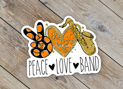 Close-up of the Peace Love Band Saxophone sticker on rustic wood