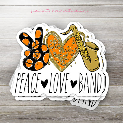 Stack of Peace Love Band Saxophone glossy stickers on a gray wood table