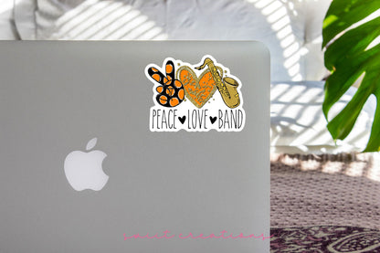 Peace Love Band Saxophone sticker on the lid of a silver laptop