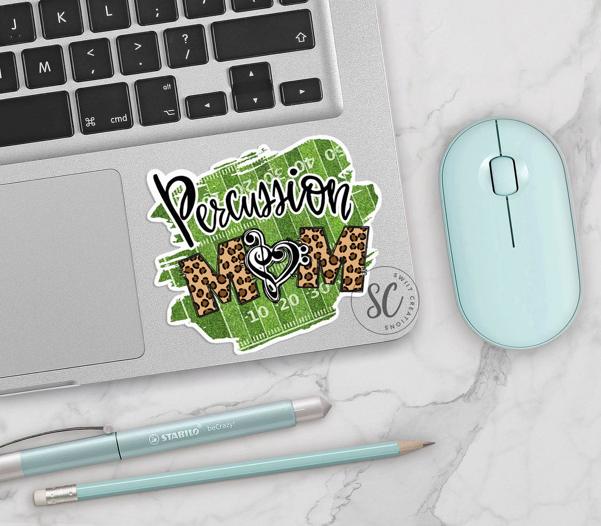 Percussion Mom vinyl sticker on a silver laptop next to a mint mouse and pens