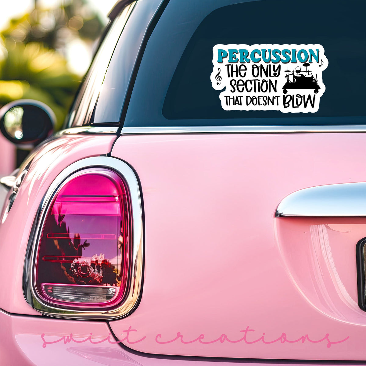 Percussion Doesn't Blow sticker on the back window of a pink car