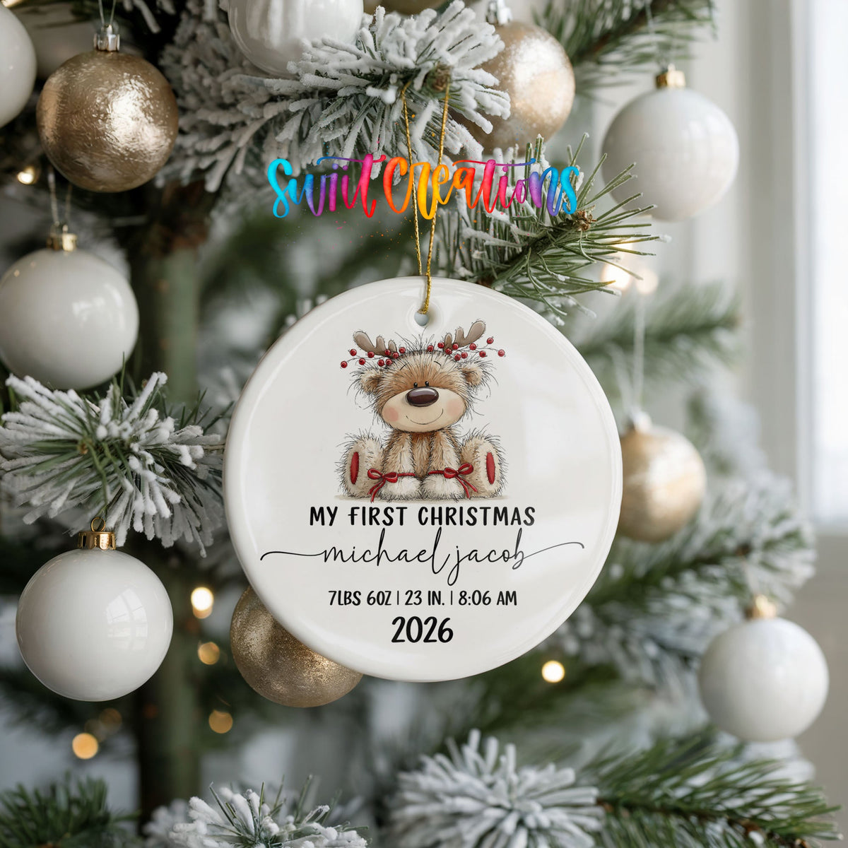 Personalized Baby’s First Christmas Reindeer Birth Stats ceramic ornament hanging on a frosted tree with white ornaments