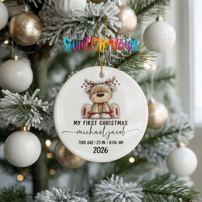 Personalized Baby’s First Christmas Reindeer Birth Stats ceramic ornament hanging on a frosted tree with white ornaments
