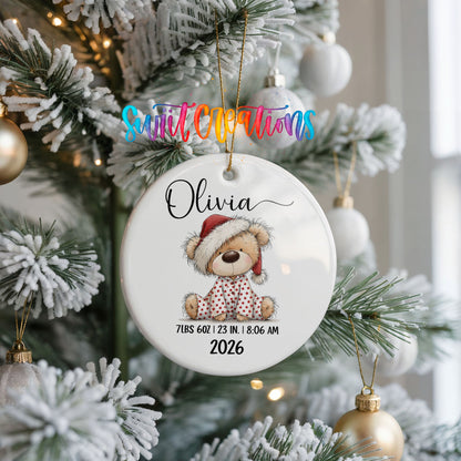 Personalized Baby’s First Christmas Santa Hat Teddy Bear ceramic ornament hanging on a frosted Christmas tree