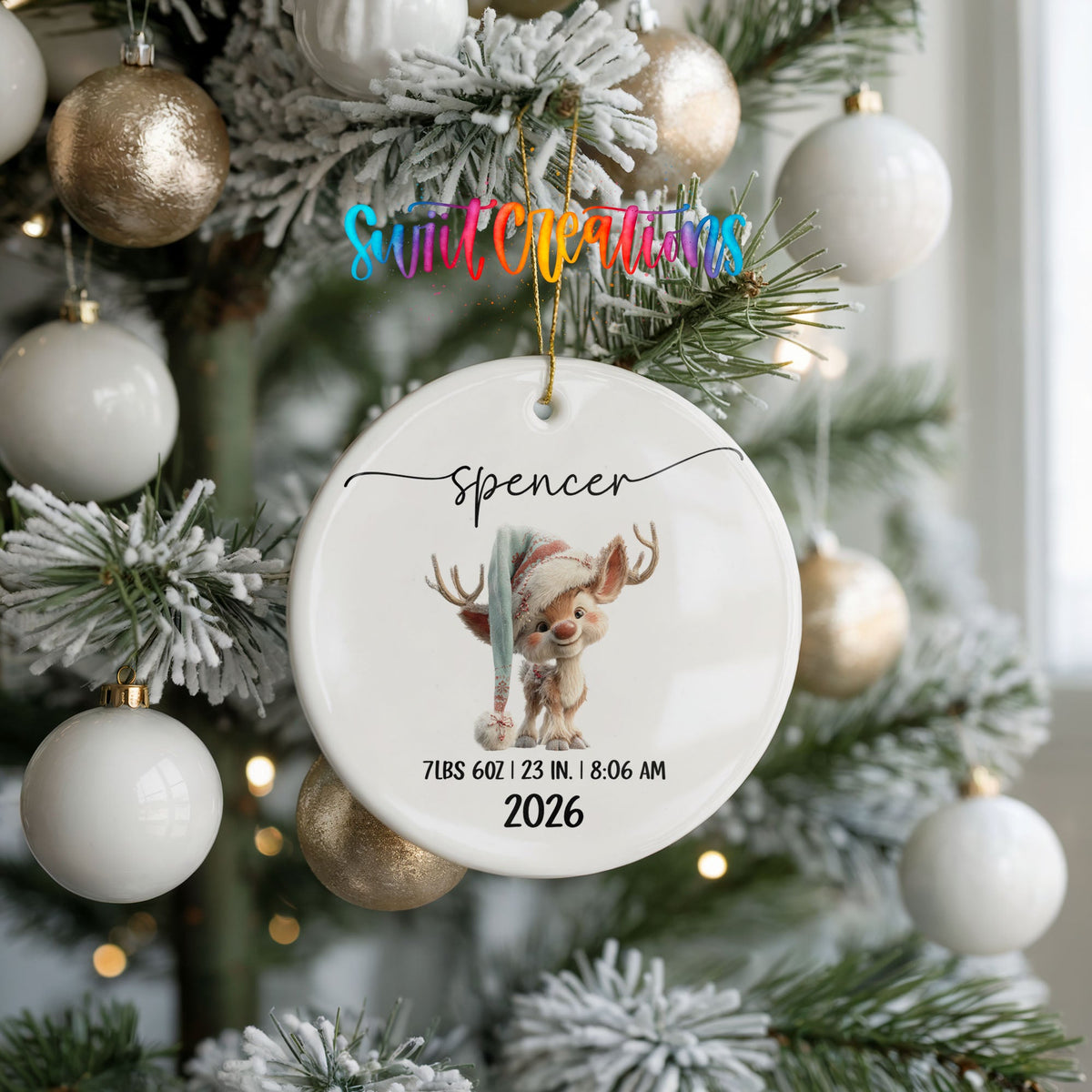 Personalized Baby’s First Christmas Winter Reindeer Birth Stats ceramic ornament hanging on a frosted tree with white ornaments