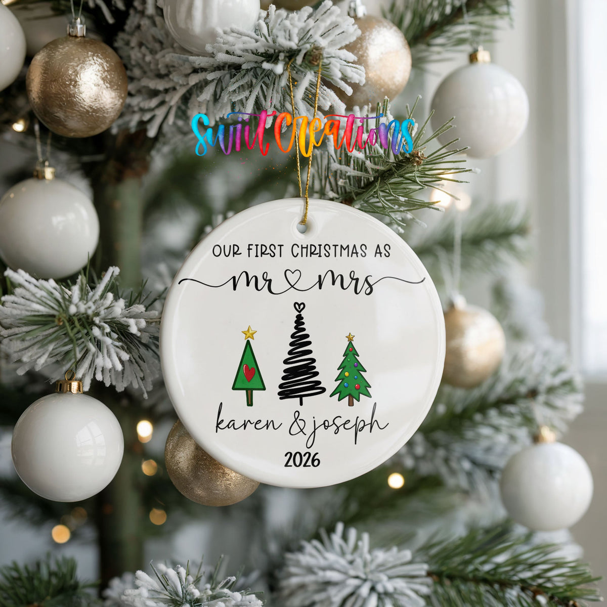 Personalized Our First Christmas Modern Tree Couple ceramic ornament hanging on a frosted tree with white ornaments
