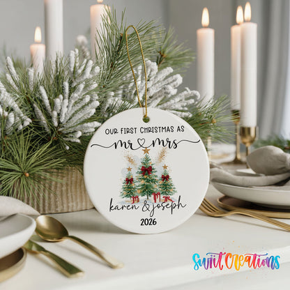 Personalized Our First Christmas Watercolor Tree Couple ceramic ornament on a holiday table with candles and greenery