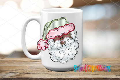 Pink and Green Santa Face UV DTF transfer on a white ceramic coffee mug