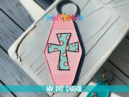 Polka Dot Cross UV DTF transfer on a pink motel keychain on a wood board