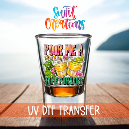 Pour Me a Shot of Some Paradise shot glass UV DTF transfer on a filled shot glass on a dock by the water