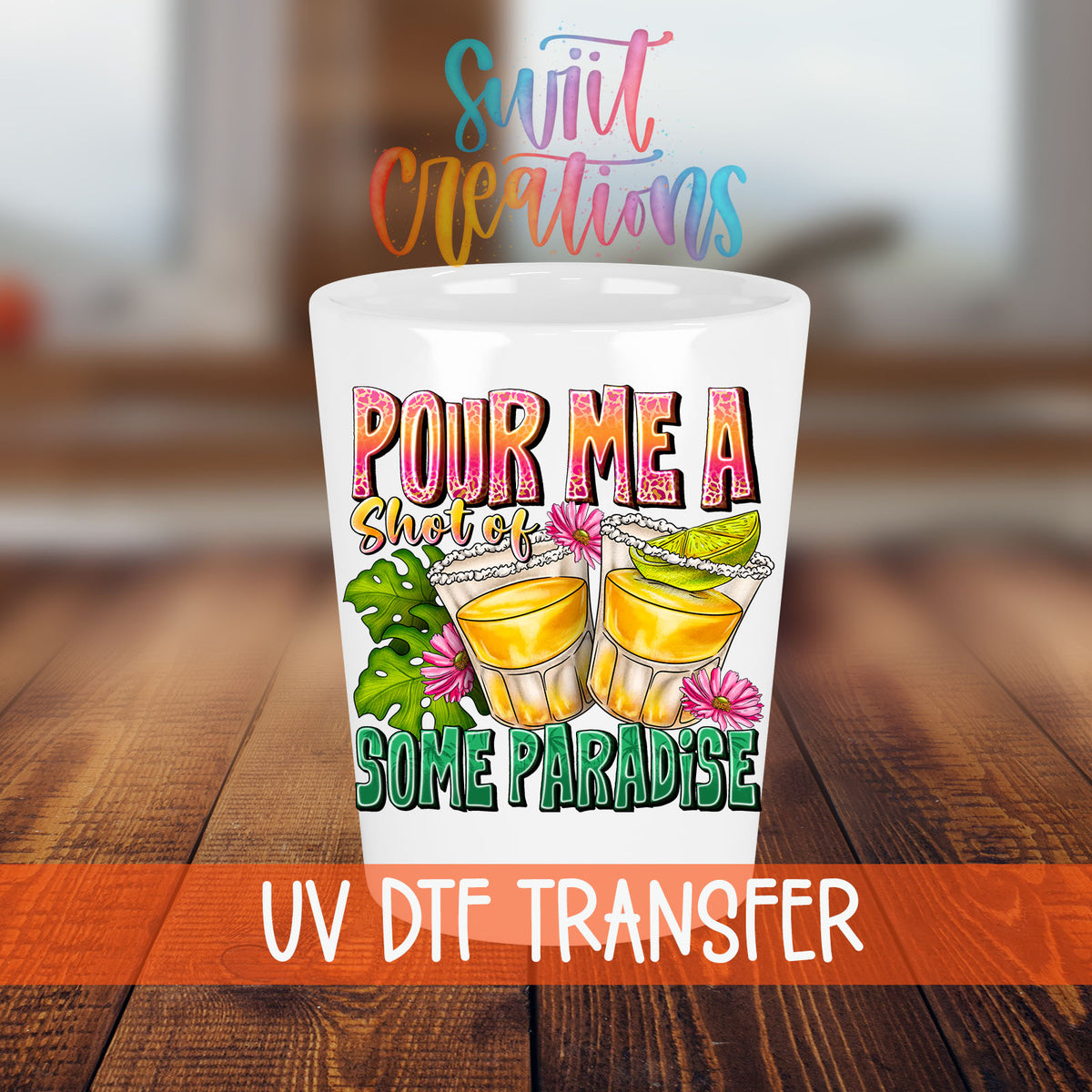 Pour Me a Shot of Some Paradise shot glass transfer on a white shot glass on a wooden table