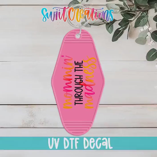 Video of the Mommin' Through the Madness motel keychain UV DTF transfer