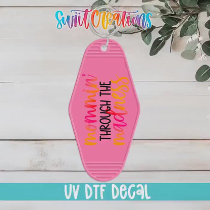 Video of the Mommin' Through the Madness motel keychain UV DTF transfer